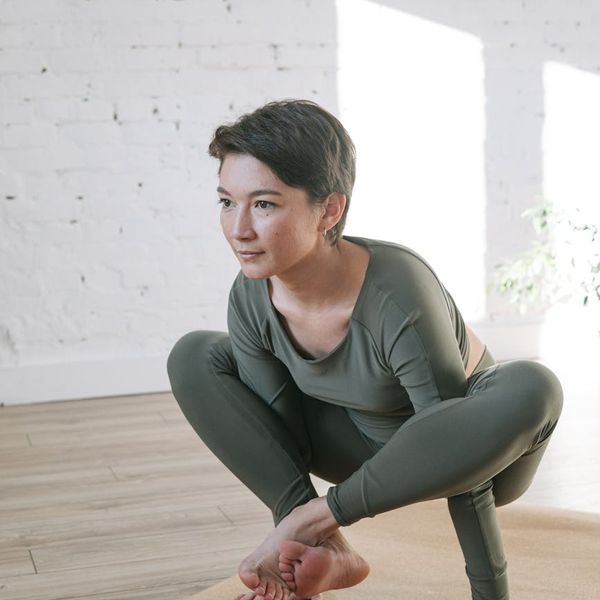 Woman in a calm yoga pose in a bright, airy room.